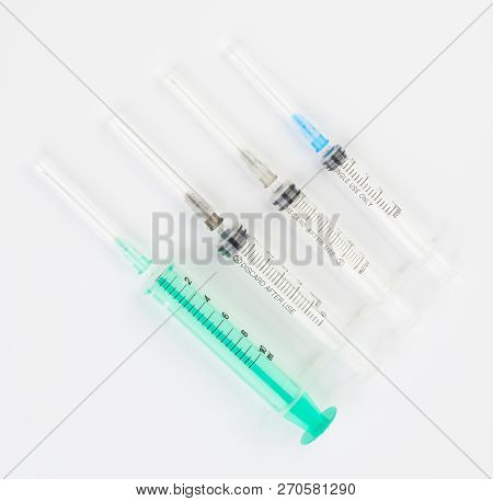 A Set Of Disposable Syringes For Injections Of Different Sizes On A White Background.