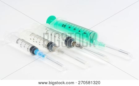 A Set Of Disposable Syringes For Injections Of Different Sizes On A White Background.