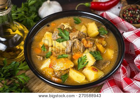 Goulash With Meat And Vegetables In Black Bowl. Beef Stew With Vegetables. European Cuisine.