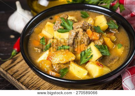 Goulash With Meat And Vegetables In Black Bowl. Beef Stew With Vegetables. European Cuisine.