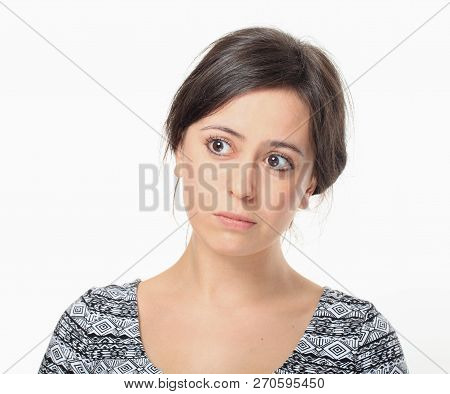 Upset Young Woman Looking Right Against White Wall