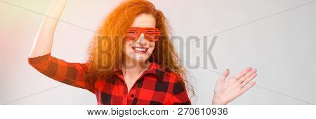 Young Red-haired Girl In A Red Checkered Shirt. Charming Young Girl In Red Glasses. Young Girl Danci