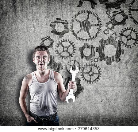 Excited Mechanic In Standing In Front Of A Wall Drawn With Engine Gear Wheels.