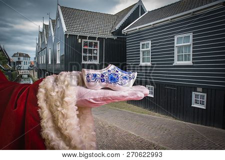Pair Of Traditional Dutch Wooden Shoes On The Background Of Typical Dutch Houses In Marek, North Hol