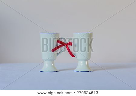 Hopefulness, Love, Support Concept. Two Cups Associated With A Red Ribbon.