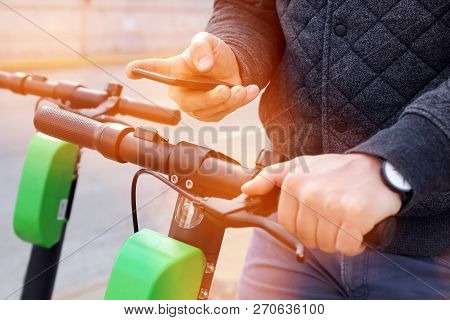 Close Up Image Of A Man On An Electric Scooter Paying Online
