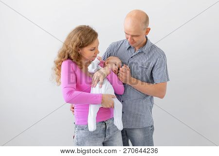 Family, Childhood And Parenthood Concept - Father, Mother Holding Cute Baby Over White Background