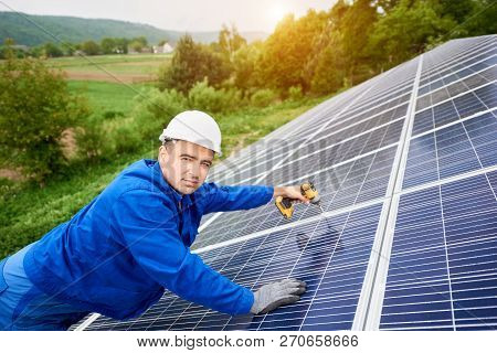 Construction Worker Connects Photo Voltaic Panel To Solar System Using Screwdriver. Professional Ins