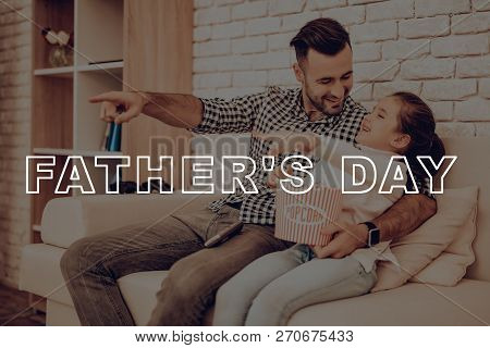 Father And Daughter Are Watching Movie On Couch. Happy Family Relationship Concept. Holiday Leisure.