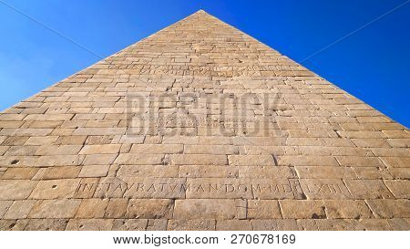 Ancient Roman Pyramid Of Cestius Against Blue Sky In Rome, Italy