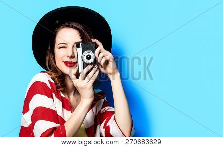 Portrait Of Young Smiling Red-haired White European Woman In Hat And Red Striped Shirt With Vintage 
