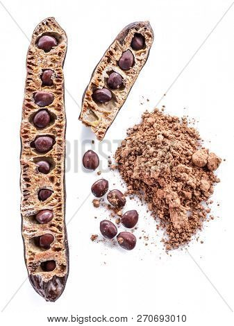 Carob pods and carob powder on the white background.