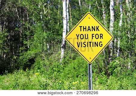 A Thank You For Visiting Sign Against A Forest Background