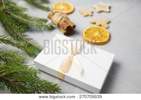 Christmas Tree Pine Brancheswith Present, Orange, Cake, Cinnamon On Grey Background. Toned