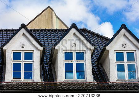 mansard windows in old style on roof in medieval house