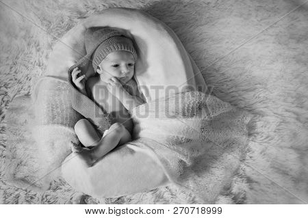 A Naked Newborn Baby Sleeps In A Christmas Hat.