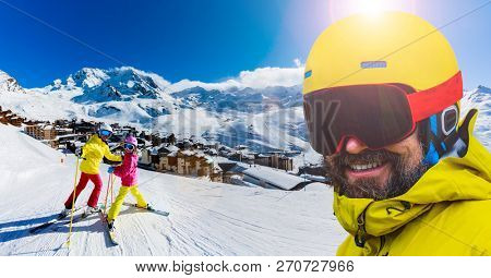 Happy family enjoying winter vacations in mountains, Val Thorens, 3 Valleys, France. Playing with snow and sun in high mountains. Winter holidays.