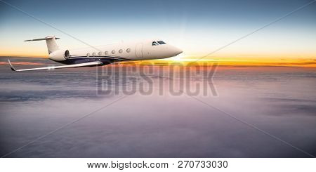 Private jet plane flying above dramatic clouds during sunset.