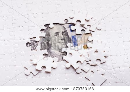 Hidden Assets Concept. One Hundred Dollar Banknote Appearing Under Puzzle Pieces