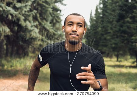 African-american Man Jogging And Listening Music At City Park