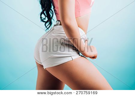 Sideways Closeup Of A Beautiful Female Figure On Blue Background.