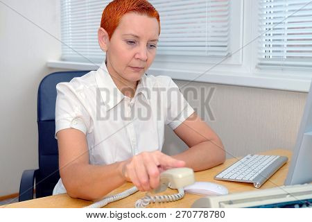 Office Manager Girl Dials The Phone Number . Thoughtful Expression