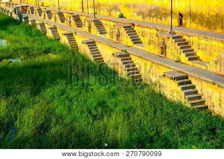Stepwell Stairs Descending On Watergrass In Udaipur, Rajasthan, India