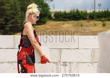 Strong Pretty Woman Working On Construction Site, Building House, Installing Gray Airbricks. Industr