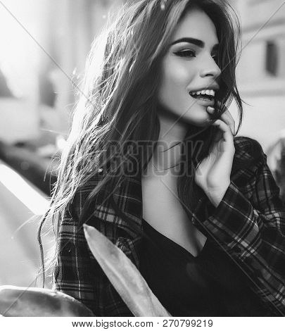 Black And White Portrait Of Young Woman In Checkered Jacket Standing Outdoor, Smiling And Holding Th