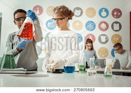 Delighted Dark-skinned Happpy Kid Demonstrating Chemical Reaction