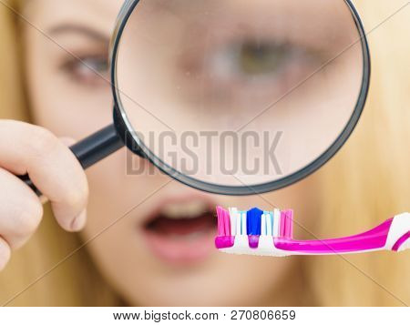 Beautiful Perfectionist Young Woman Checking Her Tooth Brush Through Manifying Loupe Glass. Hygiene,