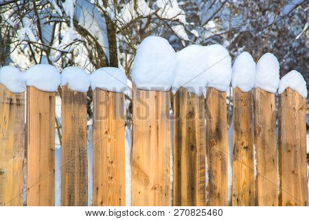 Wooden Fence Covered With White Thick Snow. Snow Cap. Winter Season. Rural Place. Snow-covered Tree 