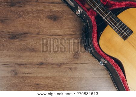 Top View Of The Acoustic Guitar In The Leather Guitar Hard Case On The Wooden Floor