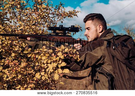 Hunting In Spring Forest. Hunter With Shotgun Gun On Hunt. Hunter Moving With Shotgun Looking For Pr