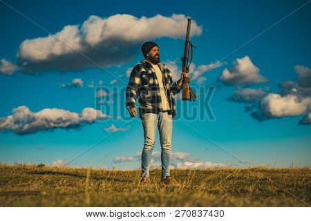 Bearded Hunter Man Holding Gun And Walking In Forest. Hunter With Shotgun Gun On Hunt