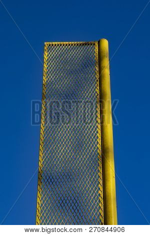 Yellow Foul Pole On Recreational Baseball Field Is Framed Against A Deep Blue Sky.