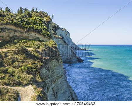 View On Of White Rock Steep Cliff Volcanic Bay Of Cape Drastis And Peroulades Area With Tropical Dee