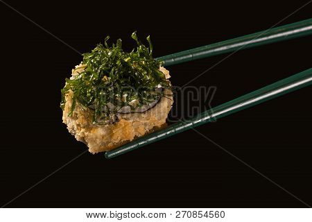 Hashi Hold Sushi And Rolls Isolated Over Black Background