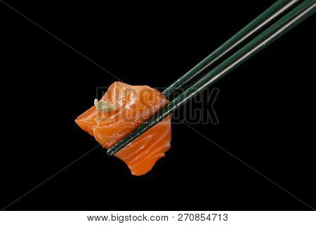 Hashi Hold Sushi And Rolls Isolated Over Black Background