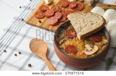 Slovak Christmas National Cabbage Soup In Ceramic Bowl With Sausage On The Tablecloth Background.