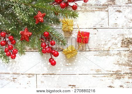 Festive Christmas Background.gift Box With White Bow And Fir Branches With Red Berries And Stars On 
