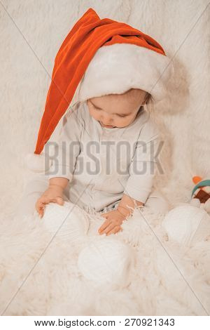 A Naked Newborn Baby Sleeps In A Christmas Hat.