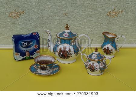 A Package Of Original English Tetleys Teabags Next An English Teacup With Saucer, Teapot, Sugar Bowl