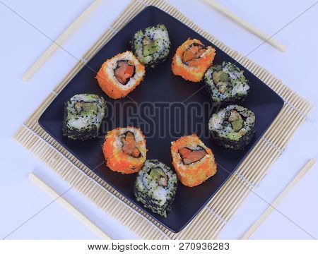 Different Types Of Maki Sushi On A Black Plate