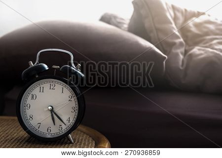 Alarm Clock On Bedside Table Made Of Wicker In Vintage Tone