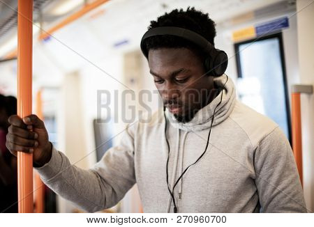 Standing passenger listening to music on the train