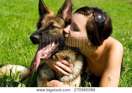 The German Shepherd Dog With Young Girl. Lovely Portrait.the Girl Kissing The German Shepherd Dog. T