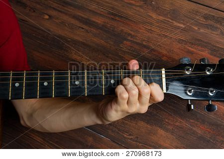 Hand Of Man Playing Six-string Guitar On Wooden Background. Template For Concert Poster