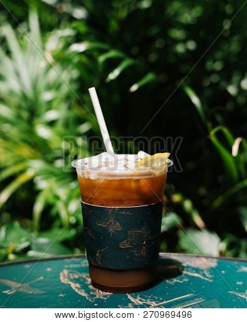 Iced cold brew coffee with lemon on a table