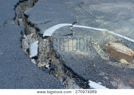 Cracks On Asphault Rural Road. Damaged Collapsed Street
